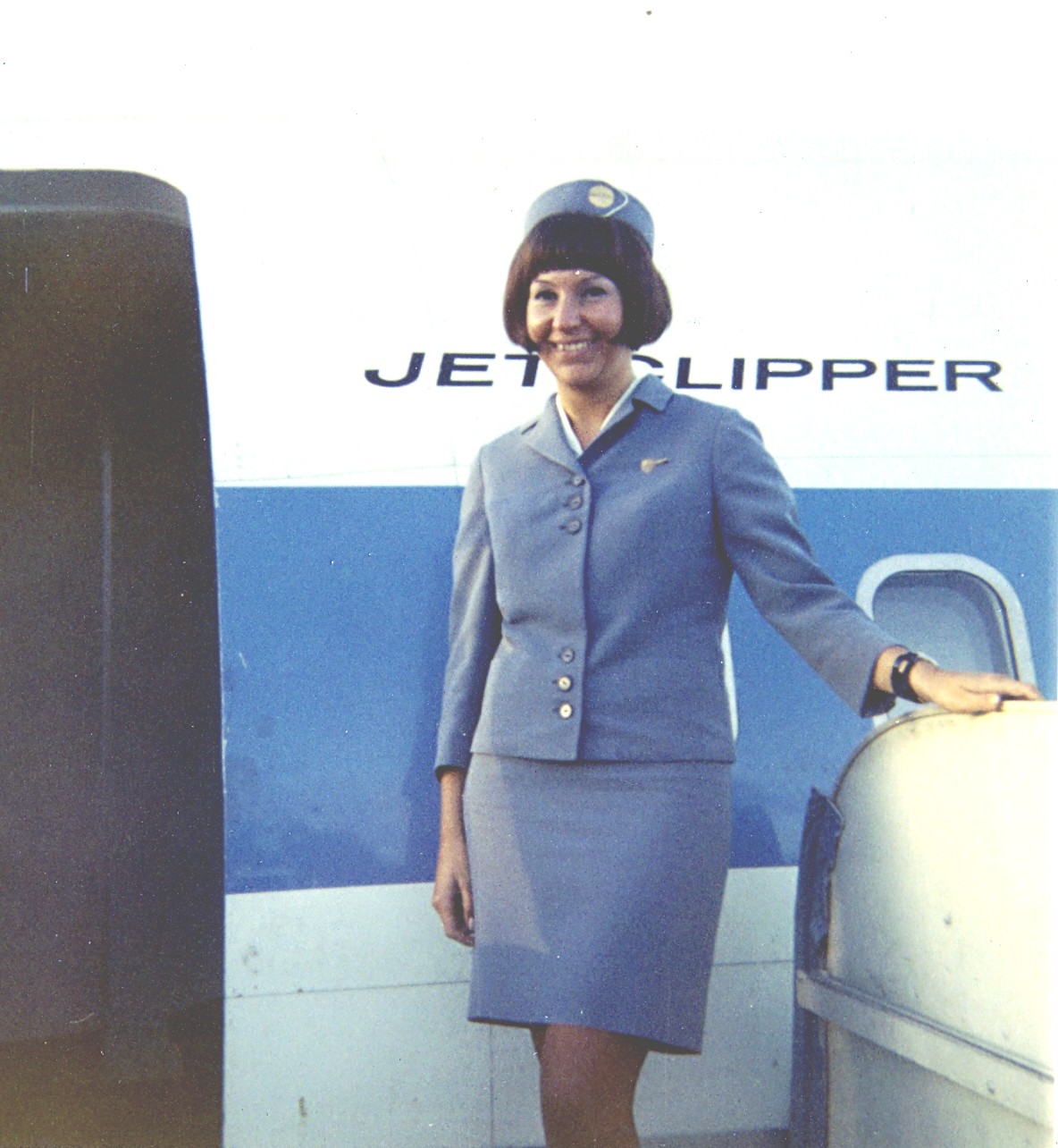1960s Maureen van Leeuwen at the front door of a Pan Am Boeing Jet ready to welcome customers.